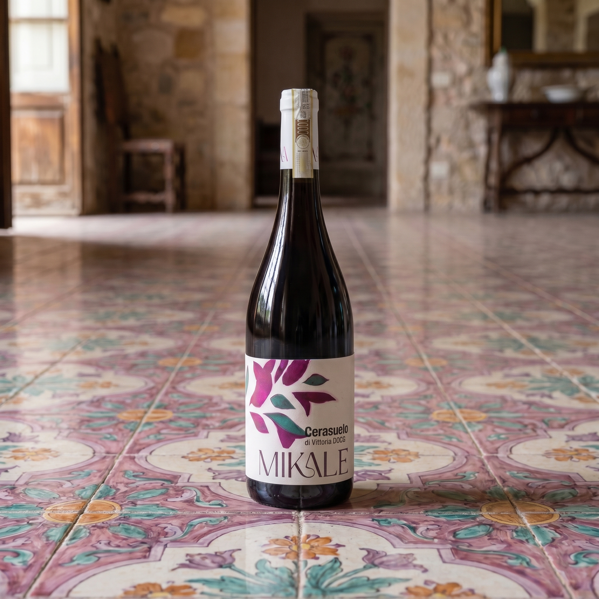 bottiglia di Cerasuolo di Vittoria DOCG di MIKALE vini, su sfondo di pavimento in piastrelle antiche siciliane