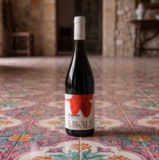 bottiglia di Frappato VIttoria DOC di MIKALE vini, su sfondo di piastrelle antiche siciliane