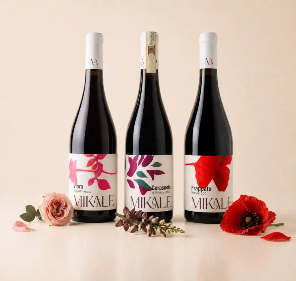 Bottiglie di Cerasuolo di Vittoria DOCG, Frappato Vittoria DOC e Rosato di frappato, della cantina Mikale su sfondo neutro.